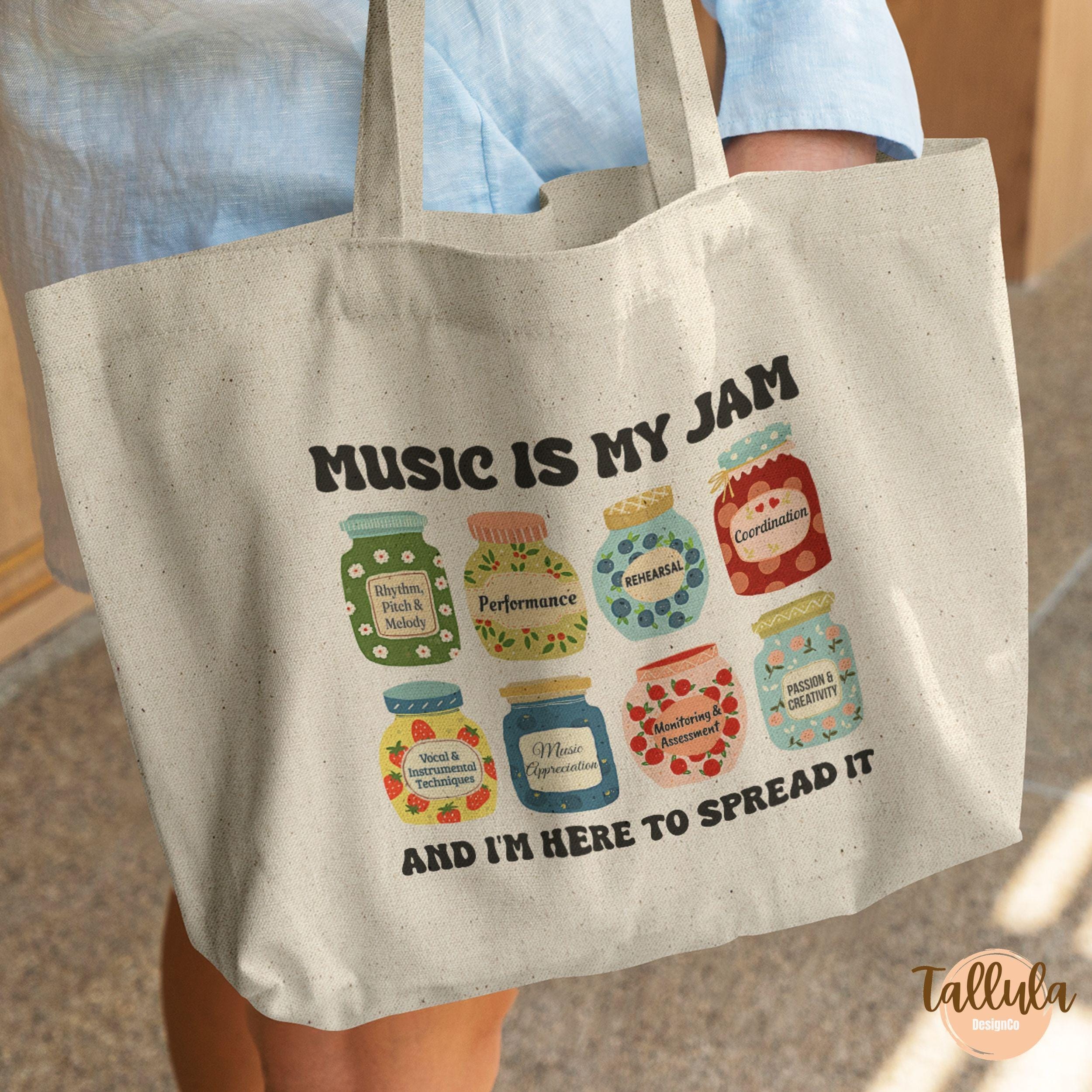 A canvas tote bag with a colorful graphic of jam jars and the text 'MUSIC IS MY JAM' and 'AND I'M HERE TO SPREAD IT'. Featuring descriptive words for each jar related to music educator, music teacher, performer.